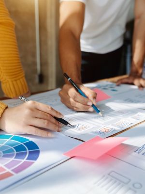 Close up view of UI developer team brainstorming on their project with laptop, smartphone and digital tablet. Creative digital development agency.